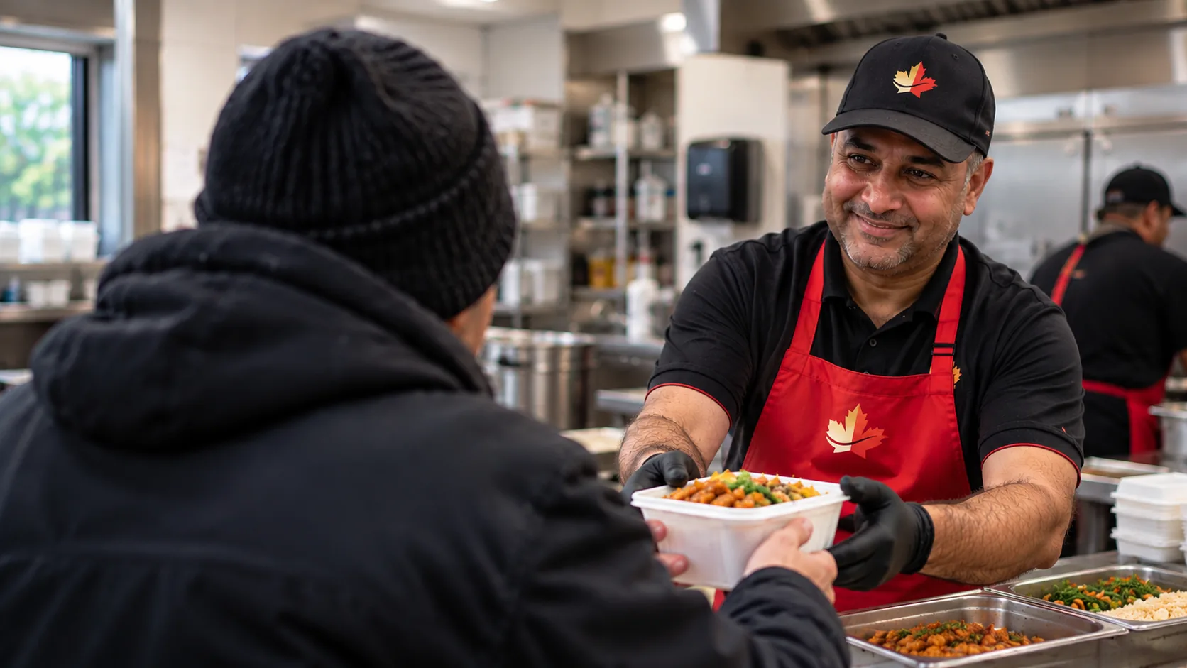A volunteer serving a hot meal at the Mapleleaf Community Kitchen