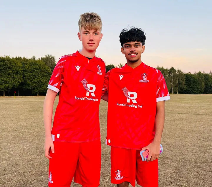 Two young players in the red Rondel Trading Ltd kit